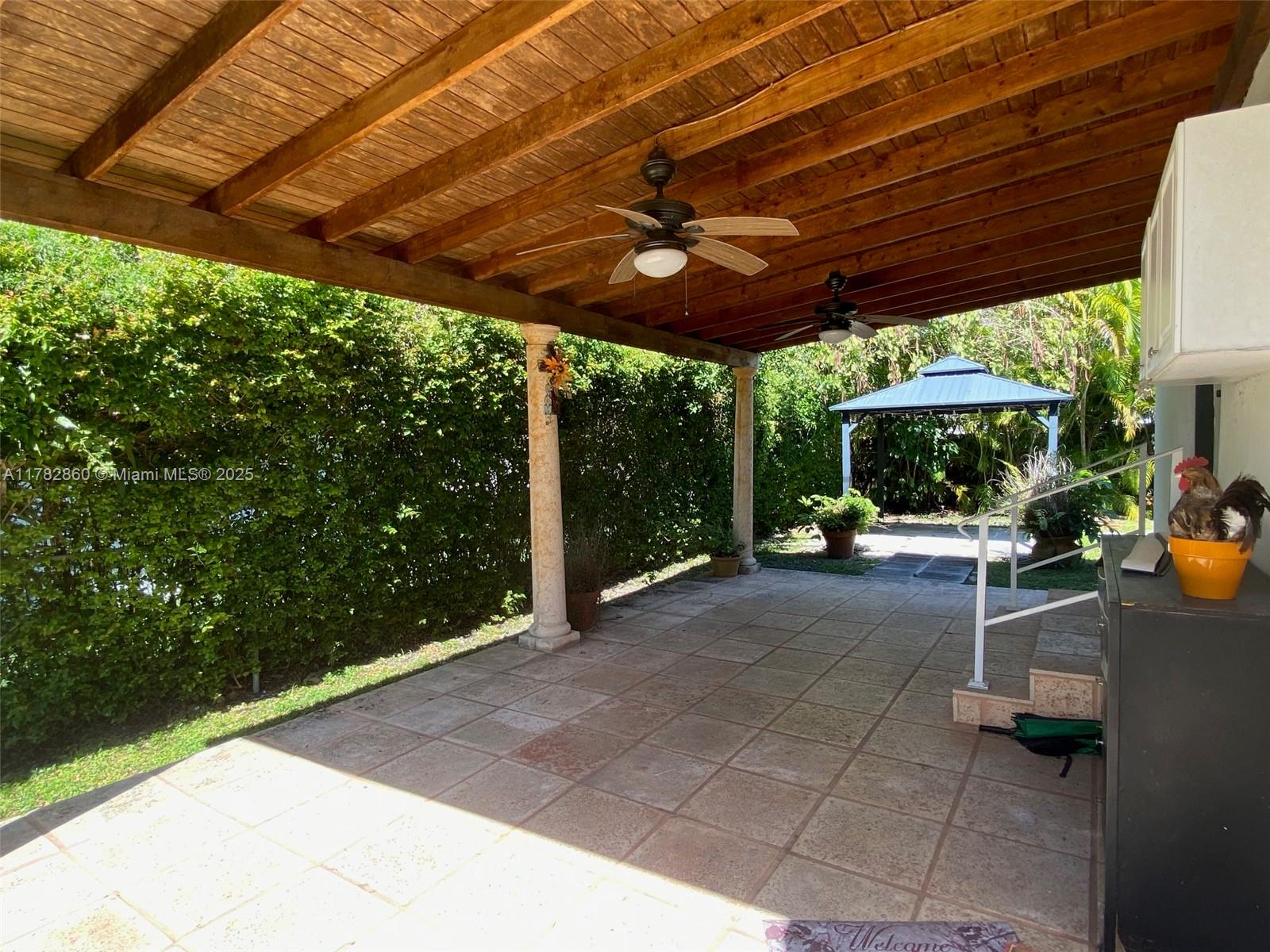 6331 Southwest 17th Street West Miami, FL 33155 - Photo 25 of 42 a view of a patio with a table and chairs under a large umbrella