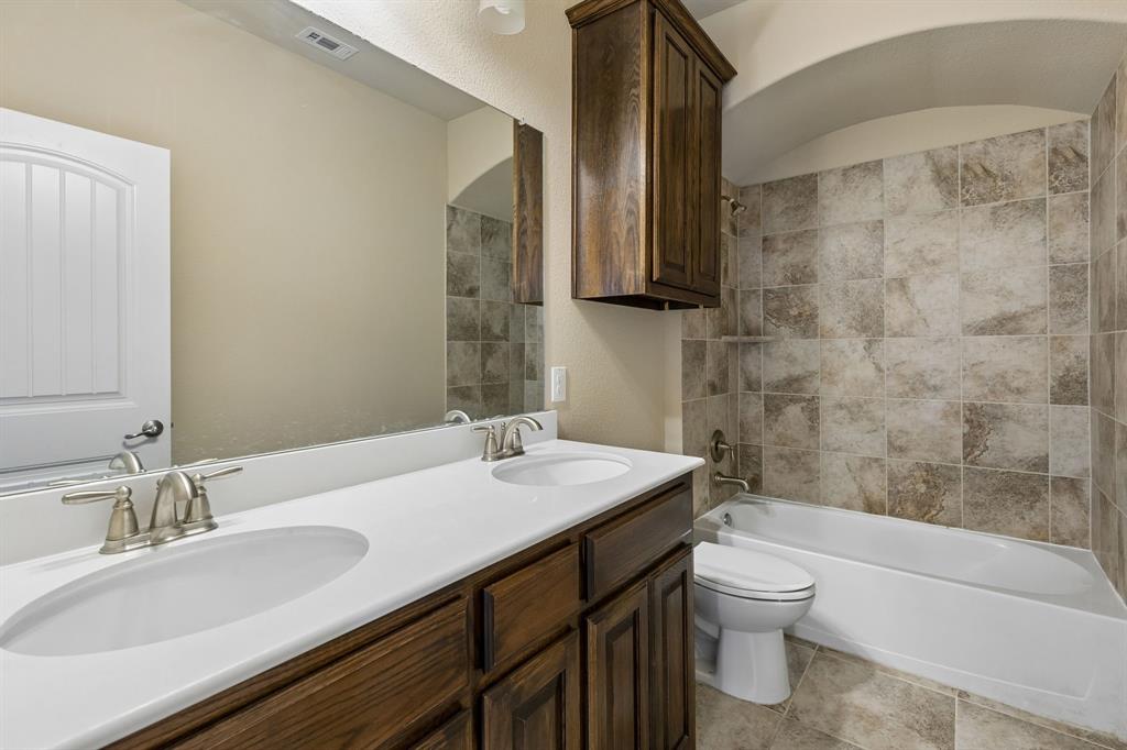 537 Hunt Farms Road Fate, TX 75189 - Photo 31 of 36 Dual vanity with integrated sinks, brushed nickel faucets, and rich wood-finish cabinetry