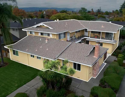 a aerial view of a house with a yard and large trees