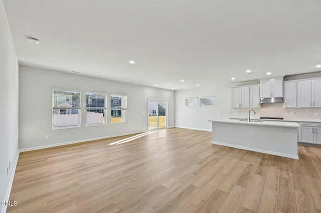a view of empty room with wooden floor and fireplace