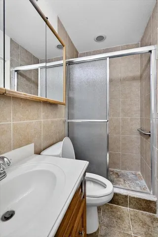 a bathroom with a sink a toilet and shower