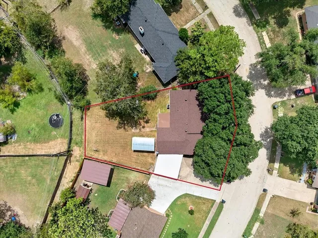 an aerial view of a house with garden space and street view