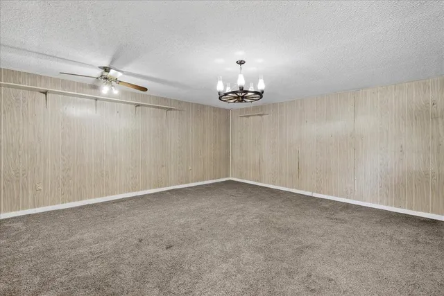 a view of an empty room with a chandelier fan