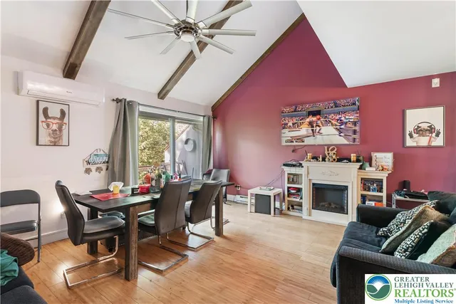 a dining room with furniture a fireplace and wooden floor