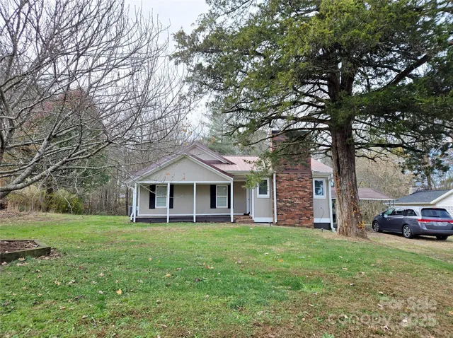 a front view of a house with a garden and trees