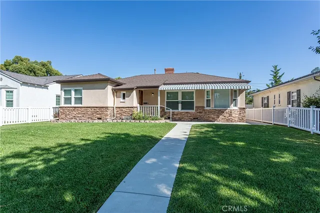 a front view of a house with a garden and yard