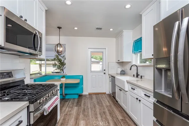 a kitchen with stainless steel appliances a stove a sink and a refrigerator