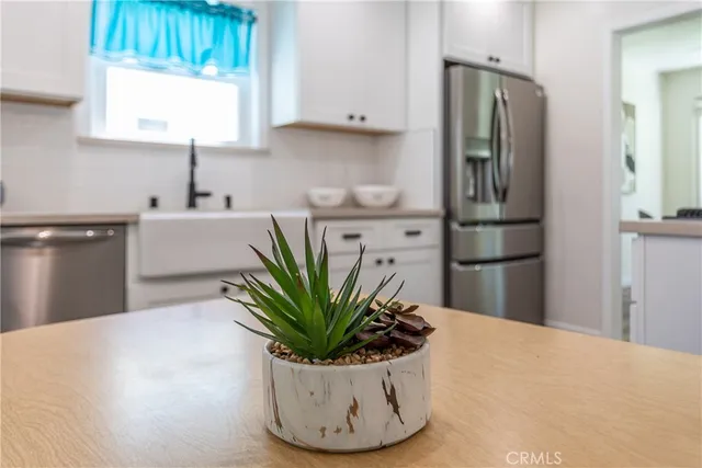 a view of a kitchen with stainless steel appliances a refrigerator and a sink
