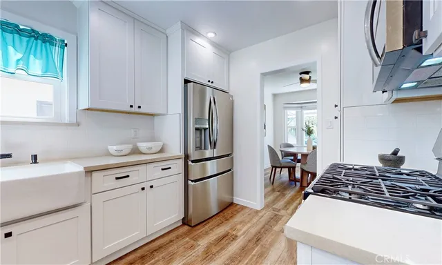 a kitchen with white cabinets and appliances