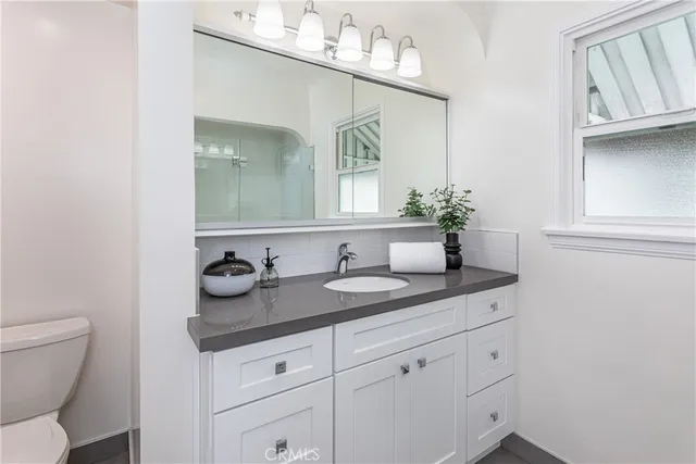 a bathroom with a granite countertop sink and a mirror