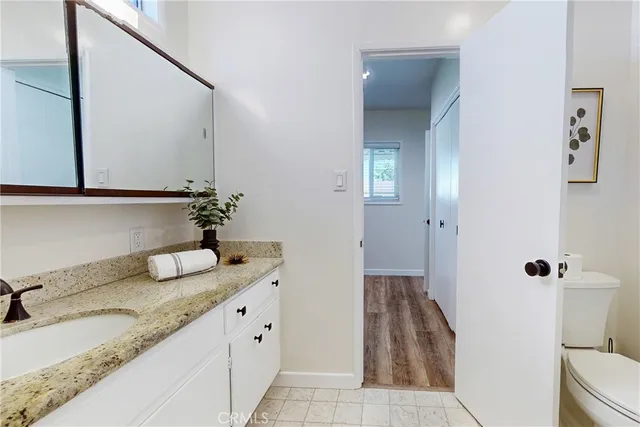 a bathroom with a granite countertop sink and a mirror