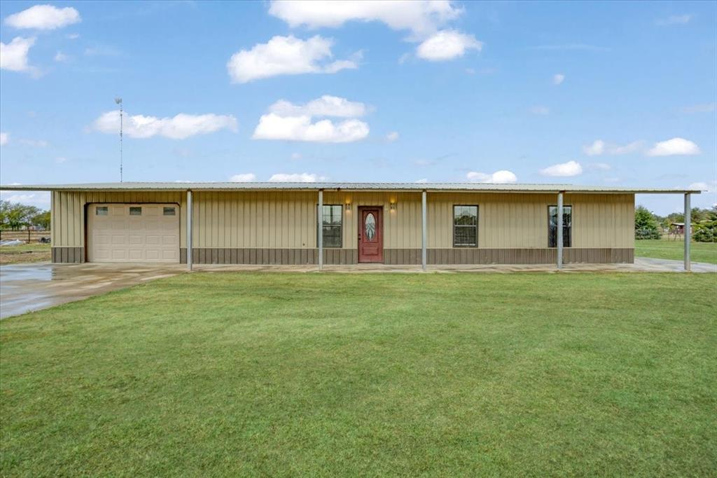 View of front of home with a front lawn and a garage