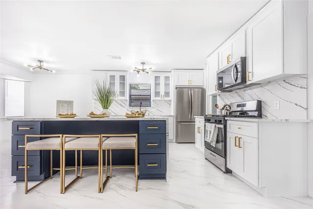 a kitchen with stainless steel appliances kitchen island granite countertop a refrigerator and stove