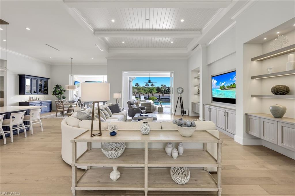 16415 Seneca Way Naples, FL 34110 - Photo 11 of 50 a living room with furniture a flat screen tv and kitchen view