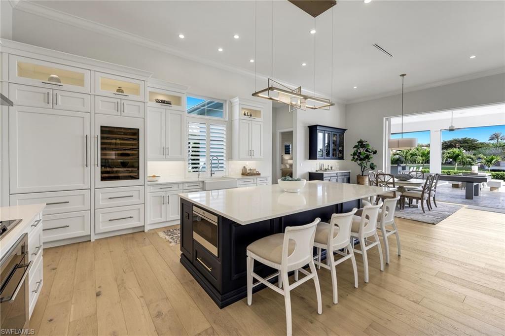 16415 Seneca Way Naples, FL 34110 - Photo 17 of 50 a kitchen with stainless steel appliances kitchen island granite countertop a table chairs and a stove