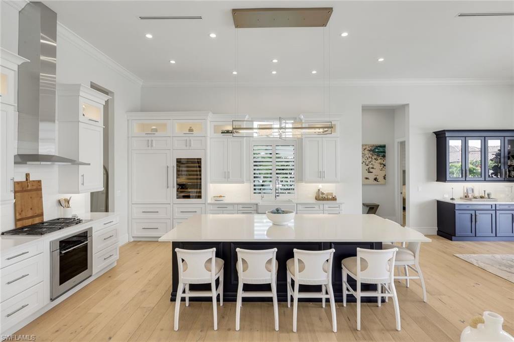 16415 Seneca Way Naples, FL 34110 - Photo 18 of 50 a kitchen with stainless steel appliances granite countertop table chairs sink and stove top oven
