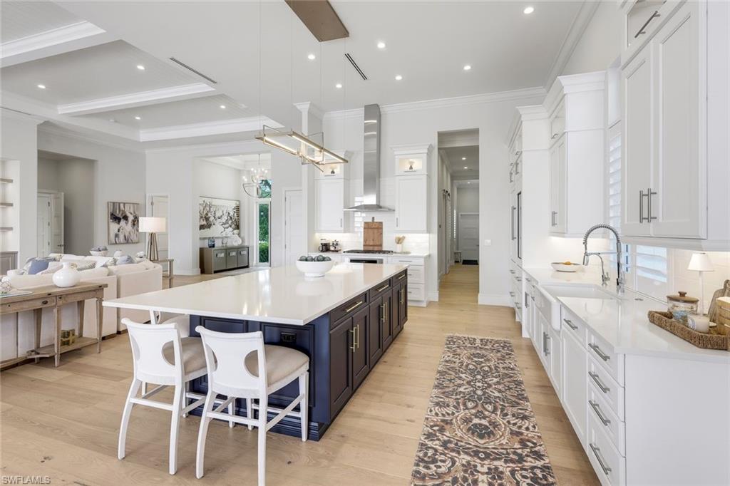 16415 Seneca Way Naples, FL 34110 - Photo 21 of 50 a large kitchen with kitchen island a sink a counter space and stainless steel appliances