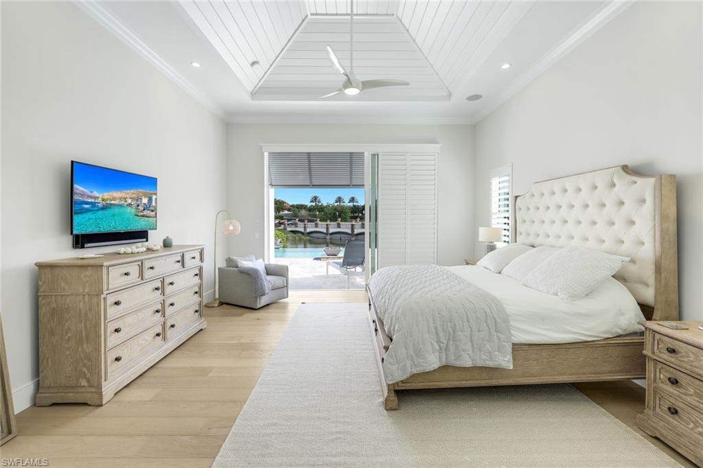 16415 Seneca Way Naples, FL 34110 - Photo 24 of 50 a bedroom with a large bed and flat tv screen on dresser