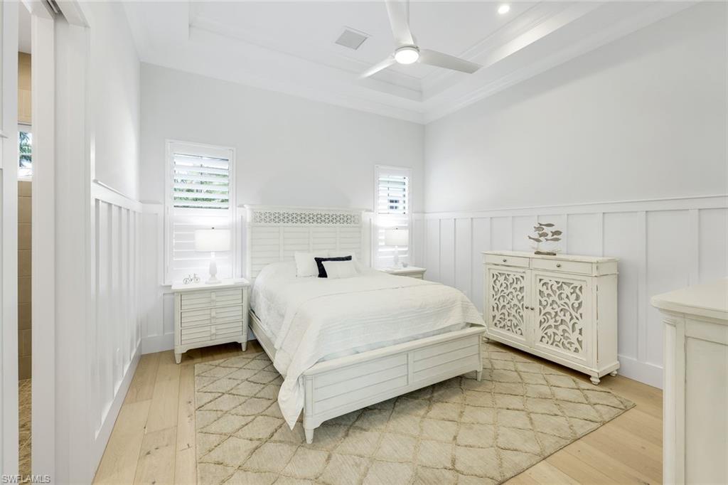 16415 Seneca Way Naples, FL 34110 - Photo 30 of 50 a bedroom with a bed and a chandelier