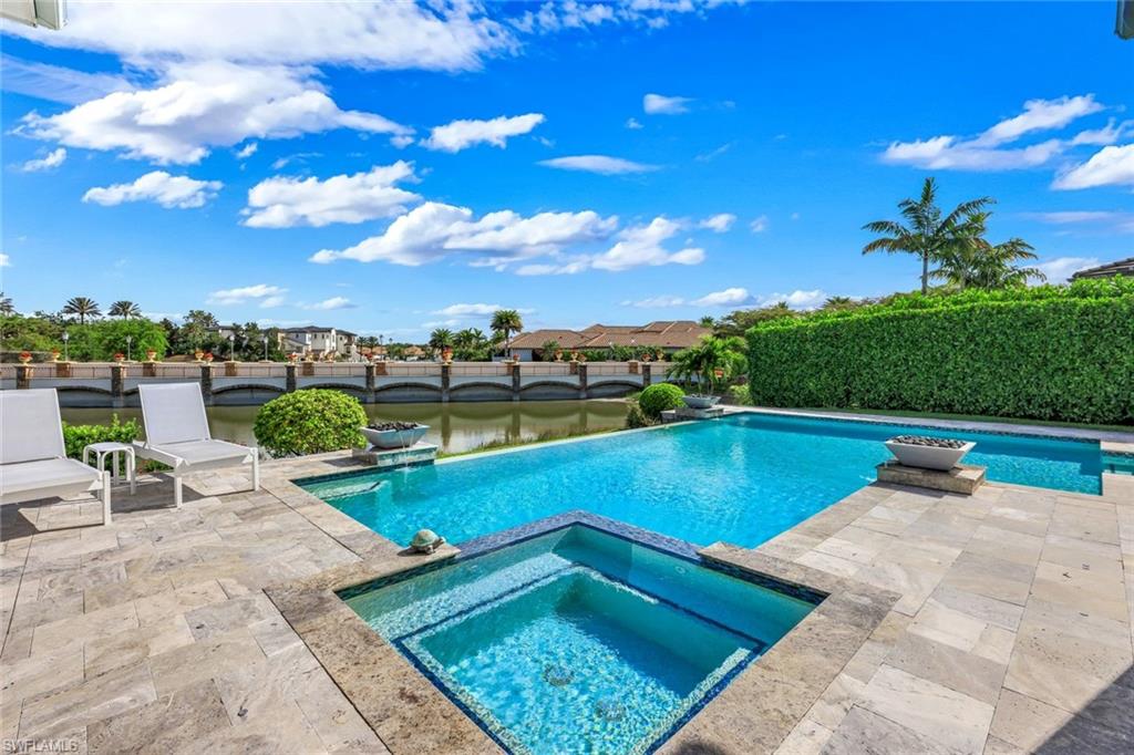 16415 Seneca Way Naples, FL 34110 - Photo 42 of 50 a view of a swimming pool with lawn chairs with plants