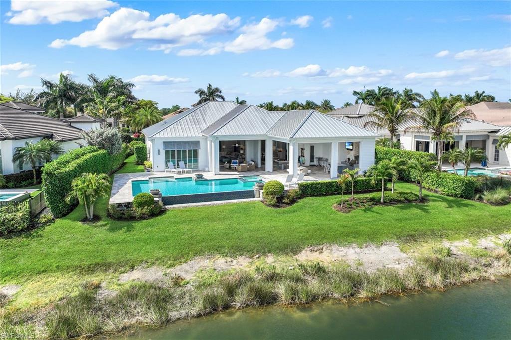 16415 Seneca Way Naples, FL 34110 - Photo 48 of 50 a front view of a house with a yard table and chairs