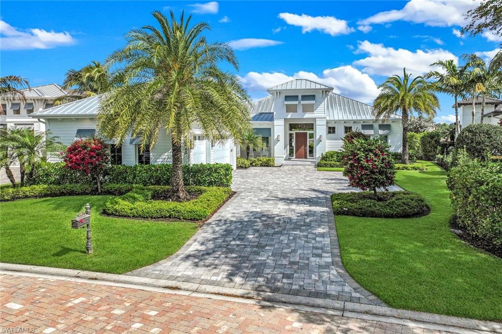 16415 Seneca Way Naples, FL 34110 - Photo 5 of 50 a front view of a house with a garden and plants