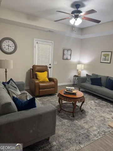 a living room with furniture a rug and a window