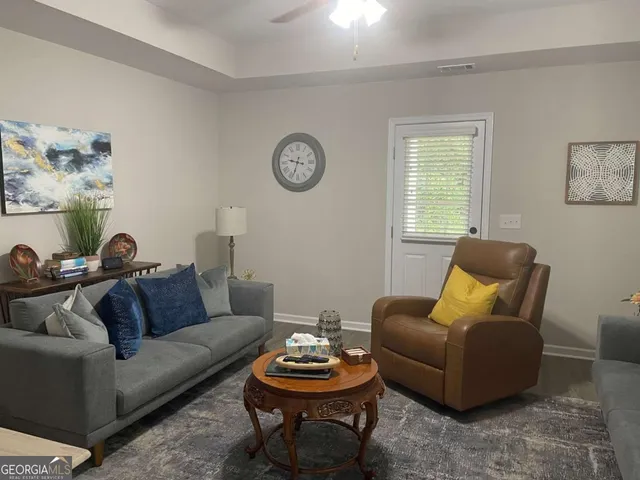 a living room with furniture a rug and a window