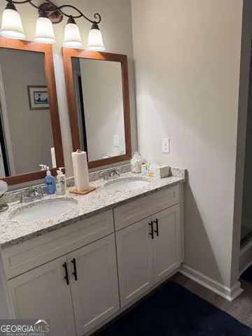 a bathroom with a double vanity sink and a mirror