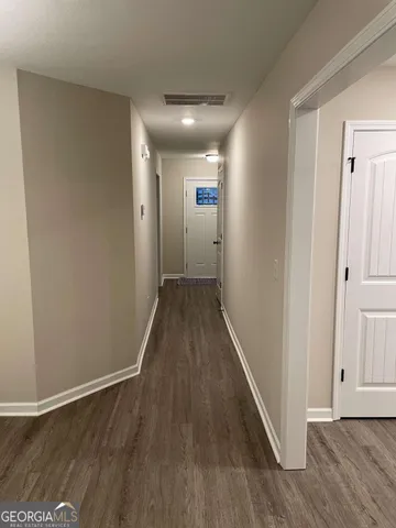 a view of a hallway with wooden floor