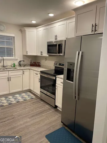 a kitchen with stainless steel appliances granite countertop a refrigerator stove a sink and a microwave