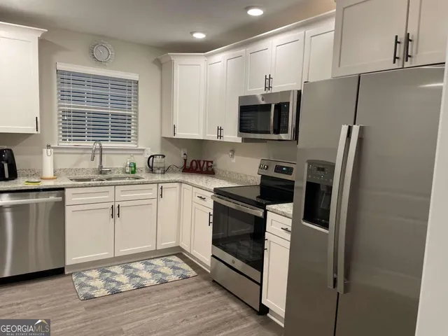 a kitchen with stainless steel appliances a refrigerator sink and microwave