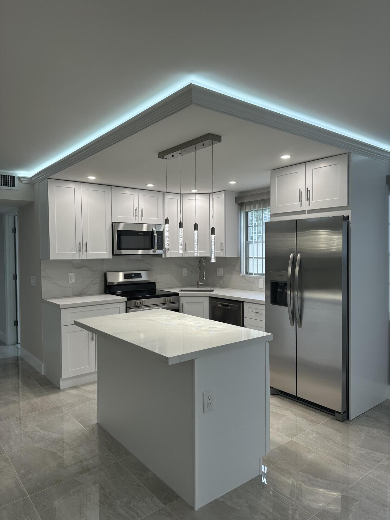 256 Suffolk F Boca Raton, FL 33434 - Photo 1 of 24 a large kitchen with stainless steel appliances kitchen island a sink refrigerator and a stove