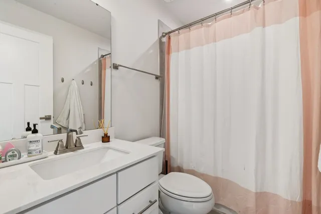 a bathroom with a sink a toilet and shower curtain