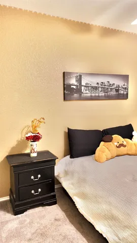 a bedroom with a bed and a lamp on dresser