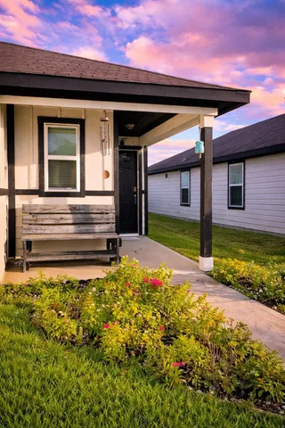 a view of a house with a small yard and a large window