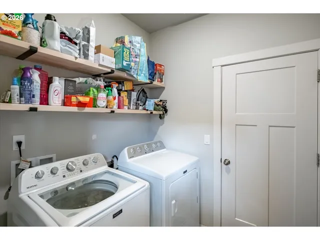 a utility room with dryer washer and storage