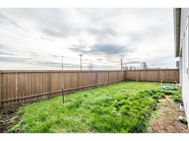 a view of a backyard with wooden fence