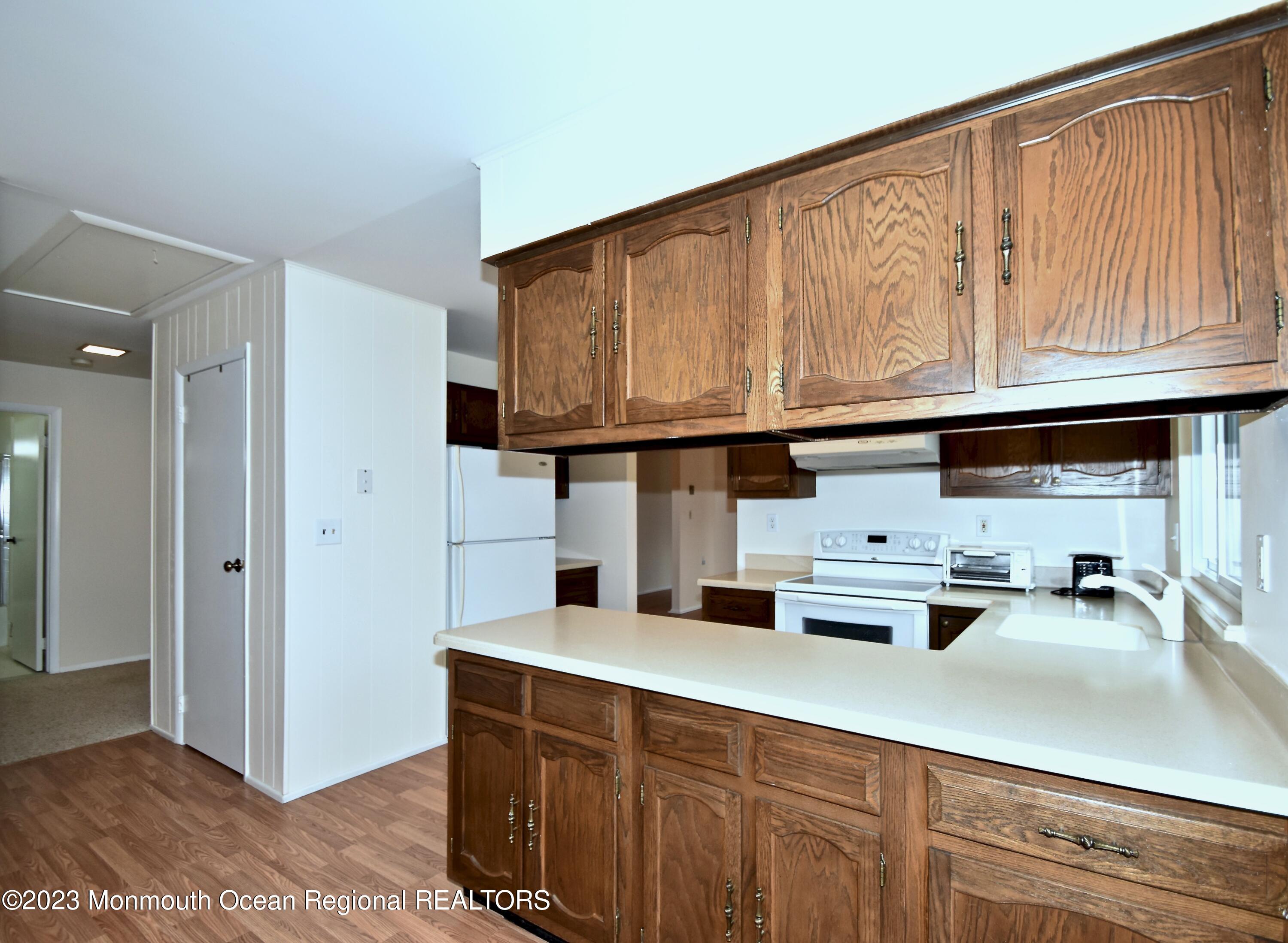 7 Flintshire Terrace Manchester Township, NJ 08759 - Photo 13 of 24 a kitchen with stainless steel appliances granite countertop a sink dishwasher stove and cabinets with wooden floor