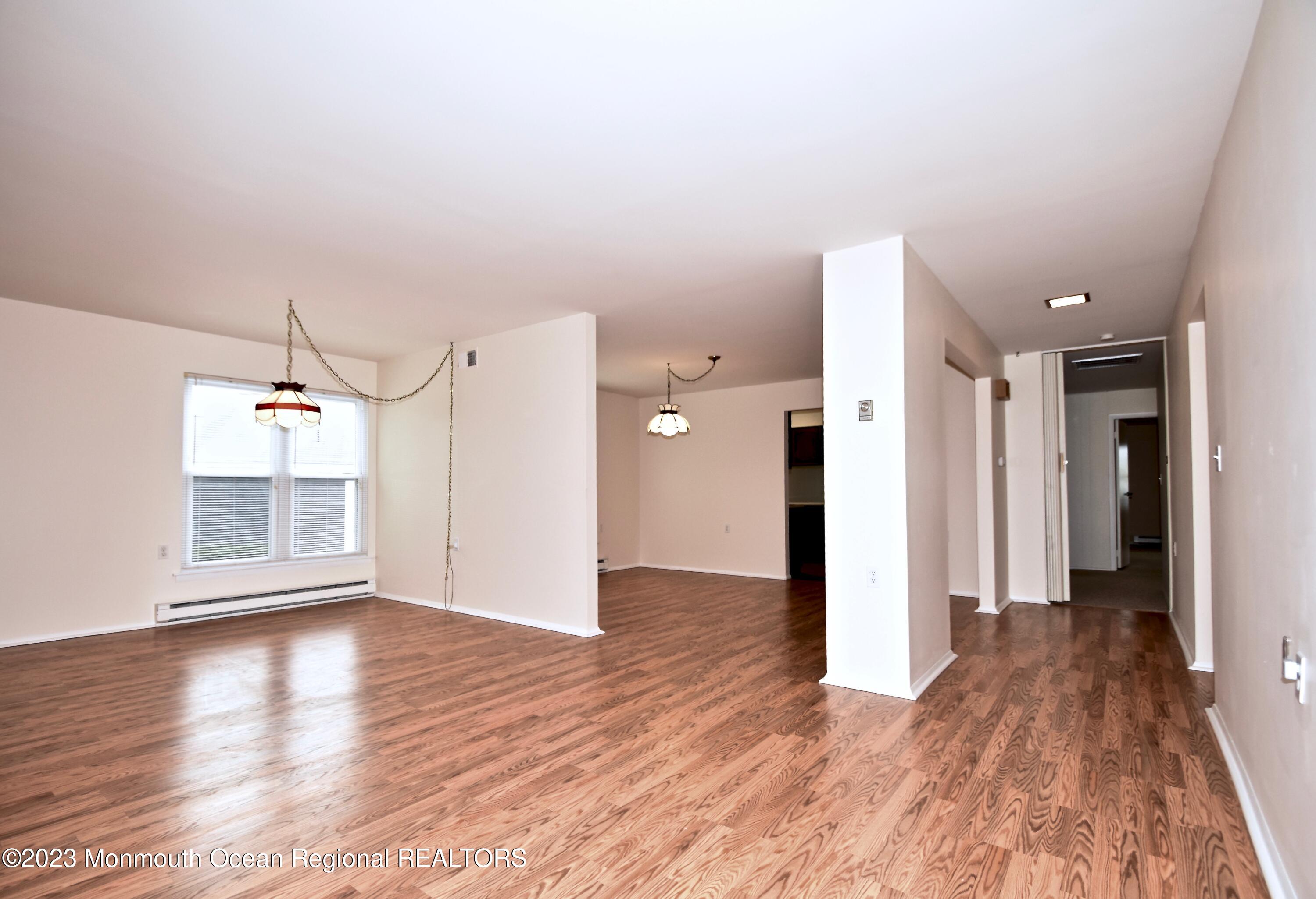 7 Flintshire Terrace Manchester Township, NJ 08759 - Photo 4 of 24 an empty room with wooden floor and windows