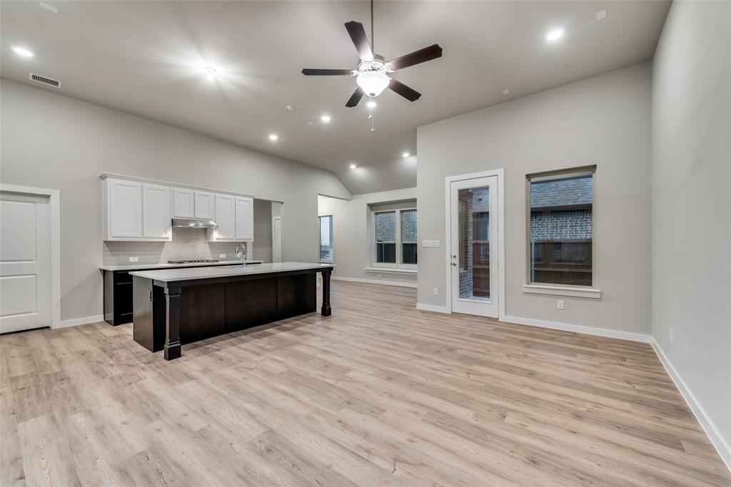 527 Embargo Drive Fate, TX 75189 - Photo 8 of 18 a living room with stainless steel appliances kitchen island furniture and a wooden floors
