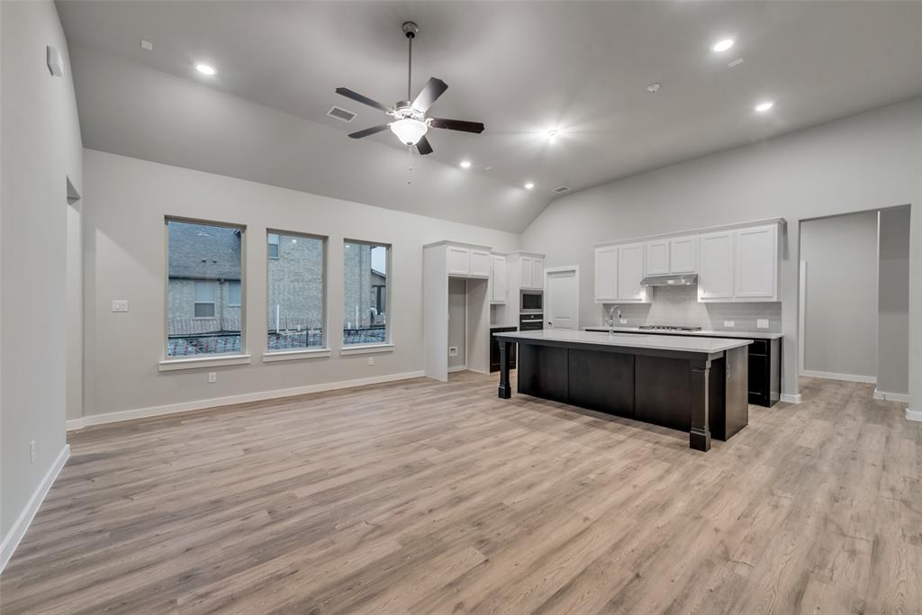 527 Embargo Drive Fate, TX 75189 - Photo 9 of 18 a large white kitchen with kitchen island a sink stainless steel appliances and cabinets