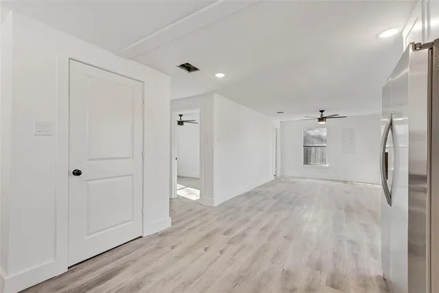 a view of empty room with wooden floor