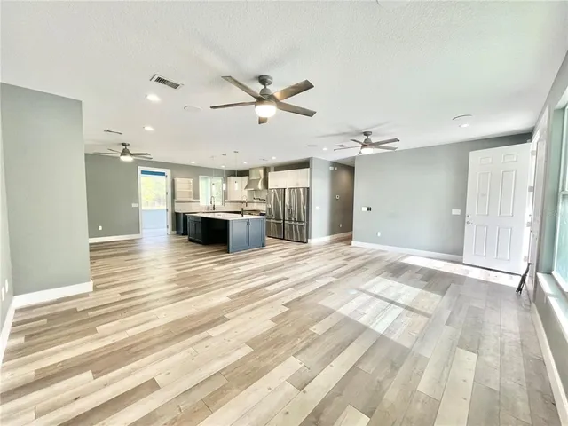 wooden floor and chandelier fan in a room