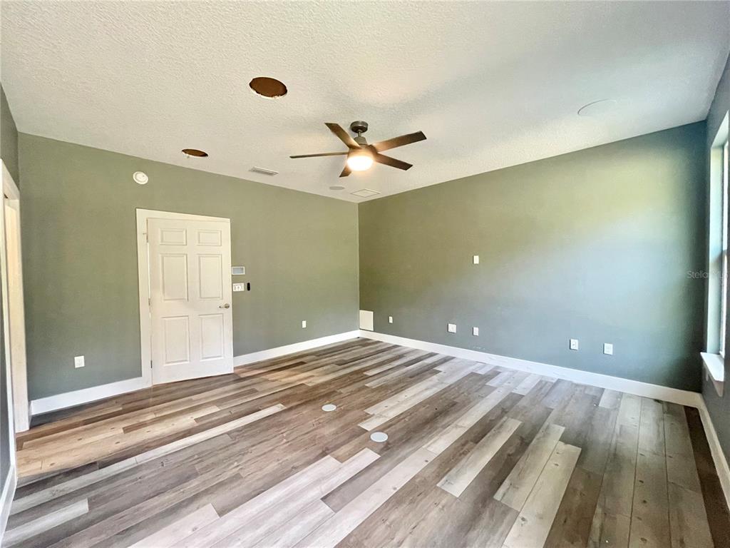 10620 Southwest 10th Terrace Micanopy, FL 32667 - Photo 13 of 58 wooden floor and chandelier fan in a room
