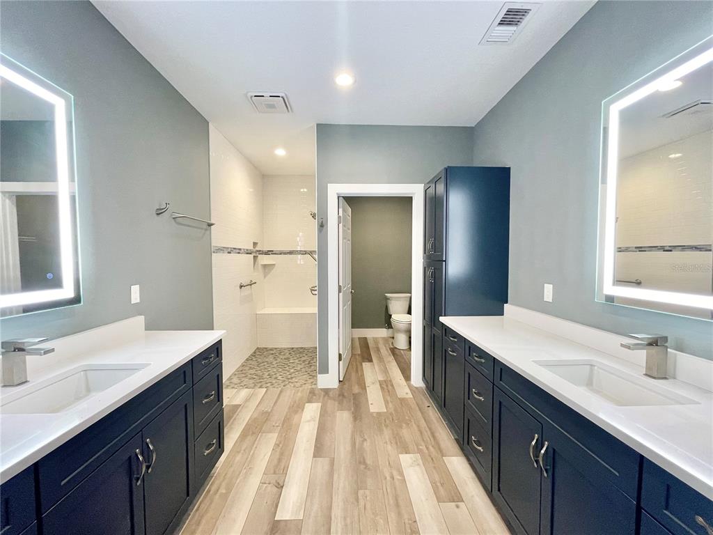 10620 Southwest 10th Terrace Micanopy, FL 32667 - Photo 15 of 58 a spacious bathroom with a double vanity sink a mirror and a shower
