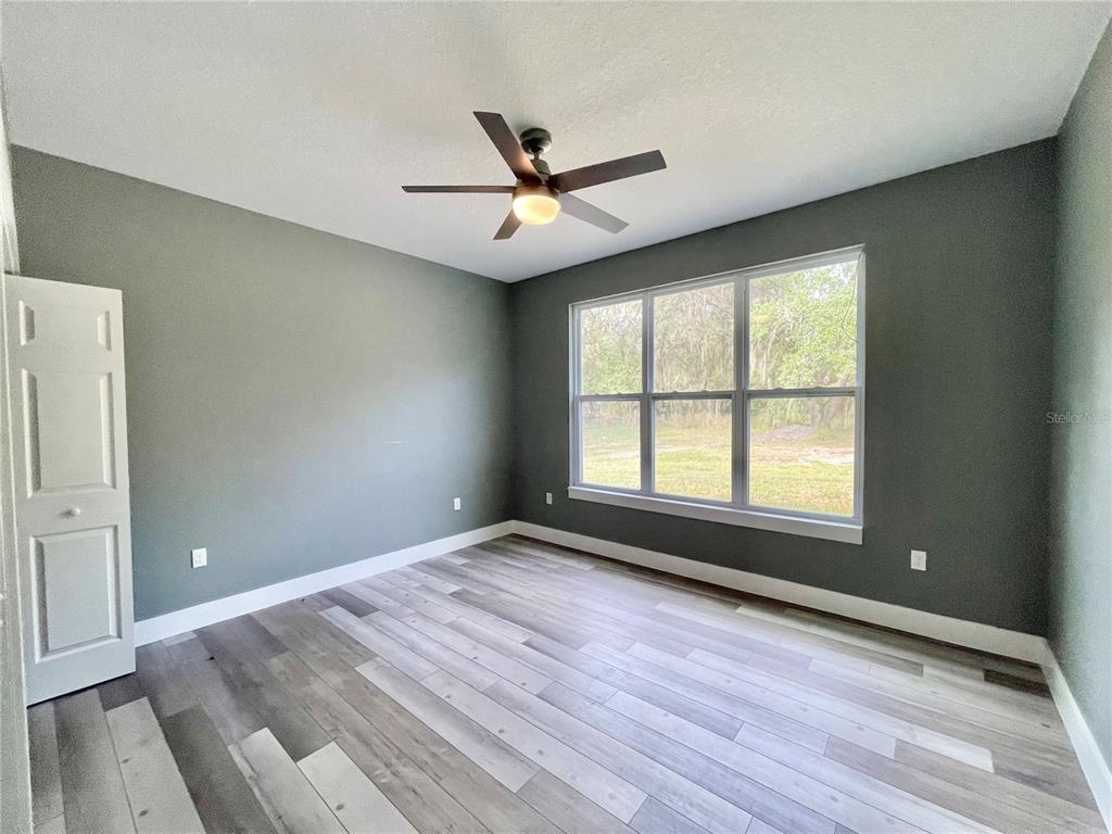 10620 Southwest 10th Terrace Micanopy, FL 32667 - Photo 24 of 58 an empty room with wooden floor fan and windows