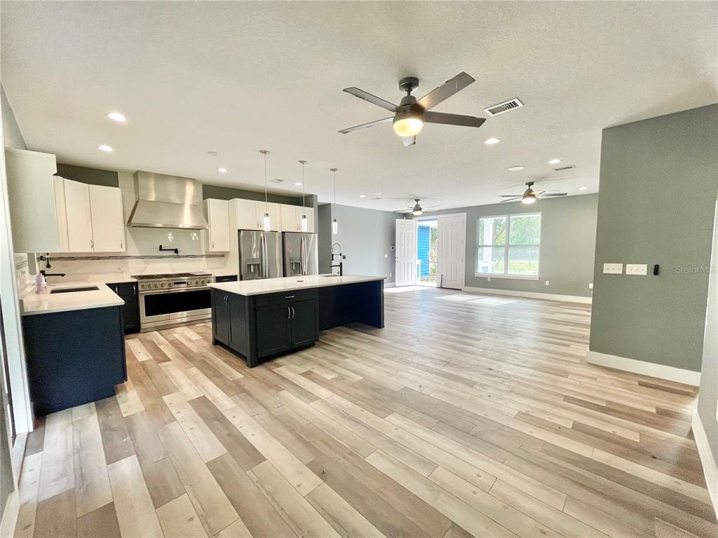 10620 Southwest 10th Terrace Micanopy, FL 32667 - Photo 9 of 58 a large kitchen with stainless steel appliances kitchen island granite countertop a refrigerator and a sink
