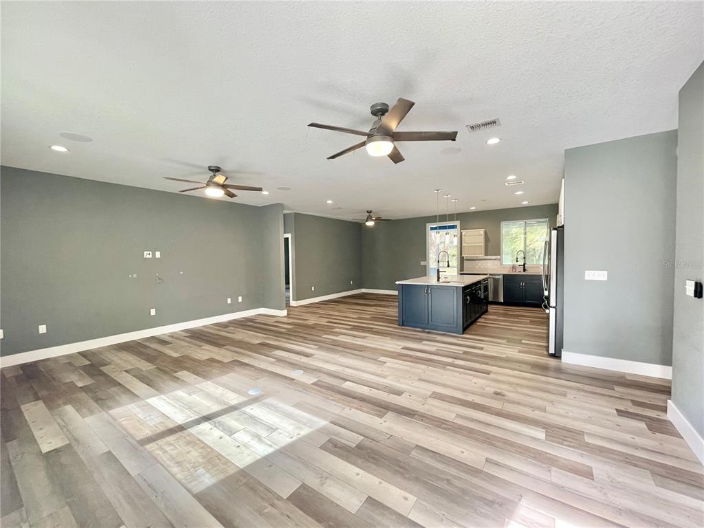 10620 Southwest 10th Terrace Micanopy, FL 32667 - Photo 10 of 58 a view of a livingroom with a chandelier fan and wooden floor