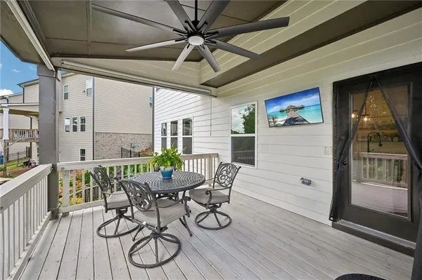 a view of a patio with table and chairs with wooden floor and fence